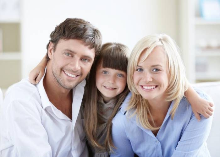 A family of three sitting together on a couch