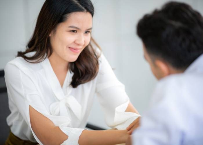 A woman converses with a man in a professional office setting